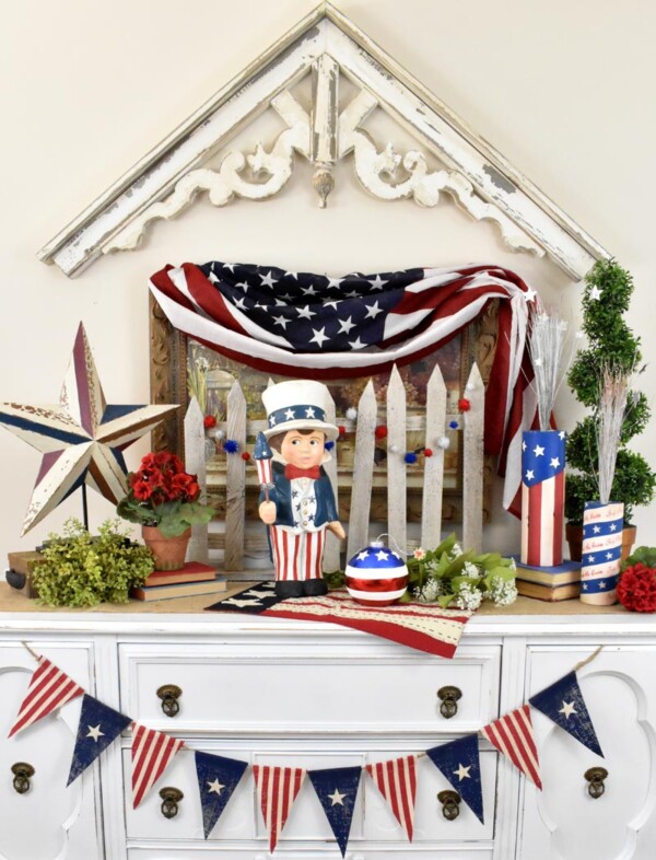 Sammys Star Spangled Banner - The paper mache figurine, Sammy, is standing in the middle of vignette on buffet. 